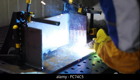 Lavoratore metalsheet taglio dalla torcia di acetilene con scintille luminose Foto Stock