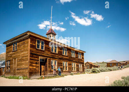 I turisti peer in una vecchia scuola abbandonata in costruzione Bodie, California State Historic Park, che una volta era un braccio di data mining town nella Sierra orientale Foto Stock