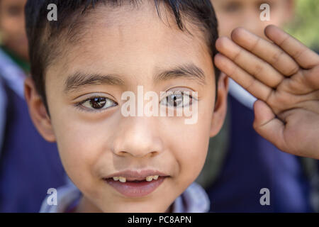 Ritratto di adorabili giovani indiani povero ragazzo frequentando il gruppo del mattino nelle zone rurali di scuola elementare. Foto Stock