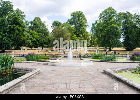 I giardini di Kensington, Giardini Italiani con persone di godersi il caldo clima estivo. Un acqua ornamentali giardino sul lato nord di Hyde park, vicino Foto Stock