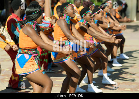 I giovani adulti Zulu donna in variopinti costumi tradizionali balli in una linea durante una street performance, Durban, Sud Africa Foto Stock