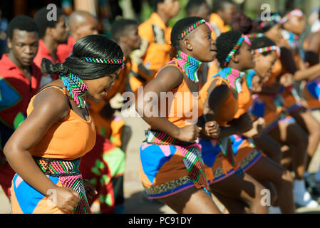 Giovani uomini e donne di strada gruppo performer esecuzione tradizionale Zulu canzoni in abiti colorati a Ushaka Marine World, Durban Foto Stock