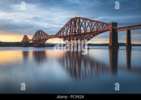 Vista del Ponte di Forth Rail, i mondi più lungo ponte a sbalzo al tramonto di una lunga esposizione, Scotland, Regno Unito Foto Stock