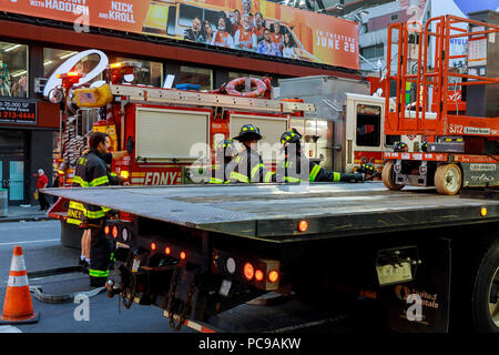 NEW YORK CITY - Jujy 02, 2018: Vigili del fuoco con il fuoco i reparti del combustibile della pompa dalla vettura dopo l'incidente Foto Stock