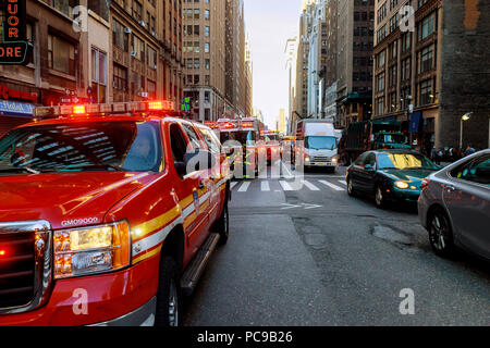 NEW YORK CITY - Jujy 02, 2018: Vigili del fuoco con il fuoco i reparti del combustibile della pompa dalla vettura dopo l'incidente Foto Stock