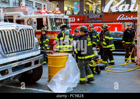 NEW YORK CITY - Jujy 02, 2018: Vigili del fuoco con il fuoco i reparti del combustibile della pompa dalla vettura dopo l'incidente Foto Stock