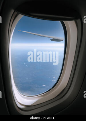 Bella vista da un aereo jet finestra alta oltre Nunavut in Canada del Nord. Sul telaio di una finestra e ala di aeroplano sono visti in primo piano. Foto Stock