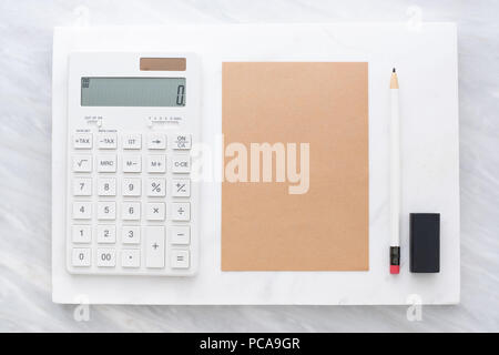 Vista superiore della calcolatrice, una matita gomma marrone e blocco note su marmo bianco di blocco e stack su marmo grigio table.Flat lay Mock up modello per aggiunta o Foto Stock