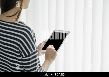 Asian business owner usura panno casuale utilizzando tablet in home office e spazio di lavoro per contattare il cliente sul canale online,office lifestyle con technolo Foto Stock