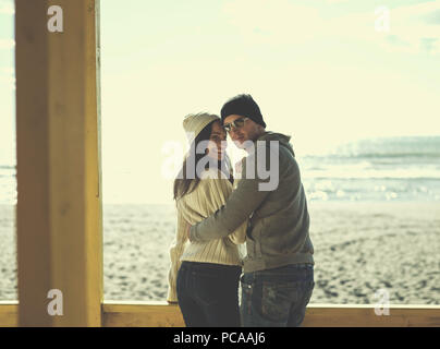 Coppia felice enyojing tempo insieme sulla spiaggia durante il giorno di autunno filtro colorato Foto Stock
