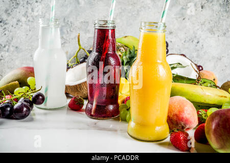Diversi succhi di frutta frullati concetto, estate vitamine dieta, con frutti tropicali e bacche su uno sfondo luminoso, Foto Stock