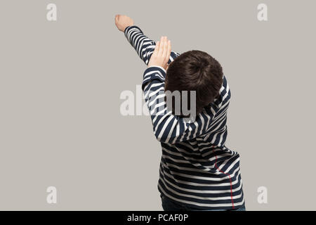 Guy rendendo Dab, ritratto in studio, isolata su uno sfondo grigio Foto Stock