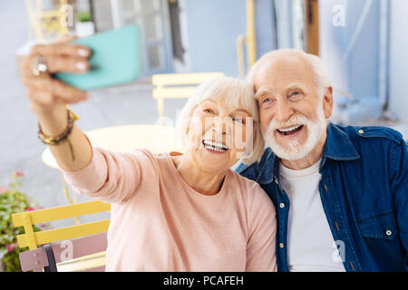 Positivo coppia senior tenendo selfie Foto Stock