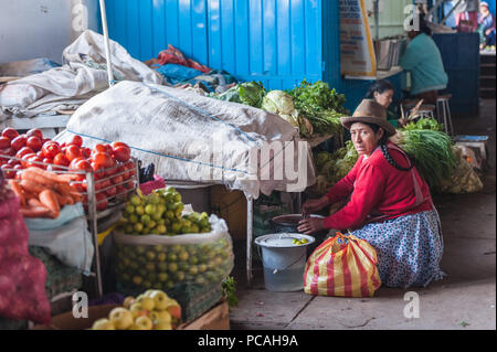 Donna locali vendono i sacchi di varie verdure come le carote, cipolle, pomodori e il cavolo, una prelibatezza locale, per la vendita sul display su un contatore a un Foto Stock