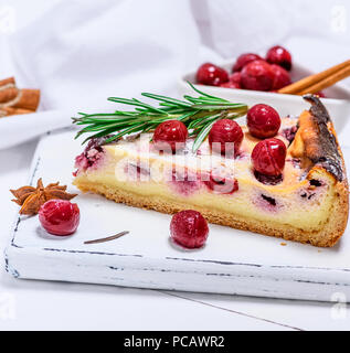 Fetta di torta al formaggio di ricotta e ciliegie marinati su un di legno bianco, scheda close up Foto Stock