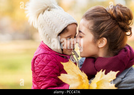 Madre e figlia piccola con foglie di autunno Foto Stock