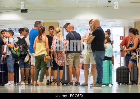 Le code all'Aeroporto di Ibiza domenica mattina come i turisti erano trattenuti come hanno cercato di tornare a casa.Un certo numero di voli sono stati annullati e ritardato con più attesi come la giornata prosegue a causa del maltempo. I turisti continuano a faccia interruzione dei voli dopo le tempeste hanno messo fine alla Gran Bretagna la canicola. Fino a 4 mila persone sono state colpite con cancellazioni di voli e ritardi finora. Foto Stock