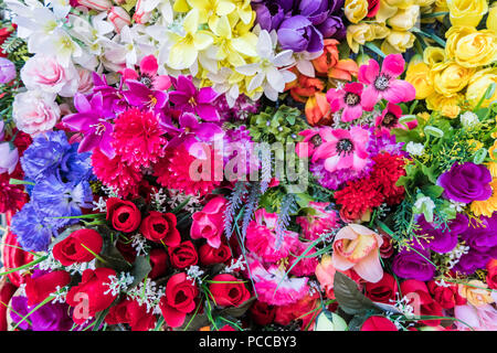 Multicolore di bellissimi fiori artificiali dello sfondo. Falsi fiori in tessuto decor. Foto Stock