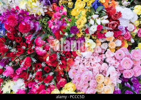 Multicolore di bellissimi fiori artificiali dello sfondo. Falsi fiori in tessuto decor. Foto Stock