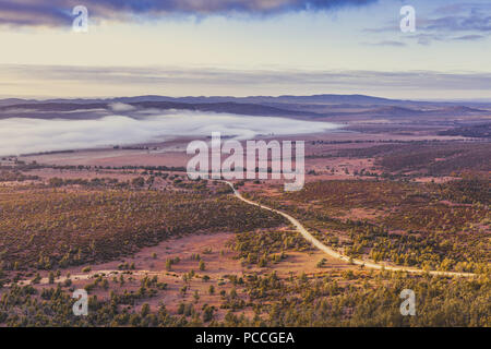 Strada sterrata avvolgimento attraverso colline e alberi in Flinders Ranges, Sud Australia sulla mattina presto Foto Stock