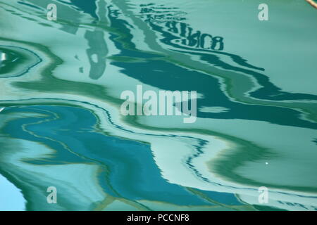 Un riflesso di una barca in acqua di mare sul porto di Limenas Thassos, Grecia Foto Stock