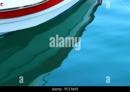 Un riflesso di una barca in acqua di mare sul porto di Limenas Thassos, Grecia Foto Stock