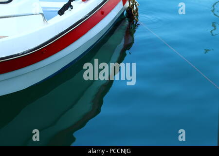 Un riflesso di una barca in acqua di mare sul porto di Limenas Thassos, Grecia Foto Stock