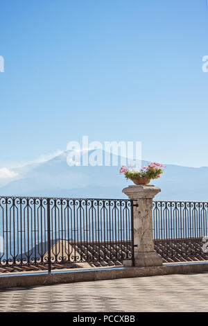 Castelmola comune Sicilia in Italia. Vista aerea della città di tetti con incredibile vulcano Etna fumante sullo sfondo, verticale Foto Stock