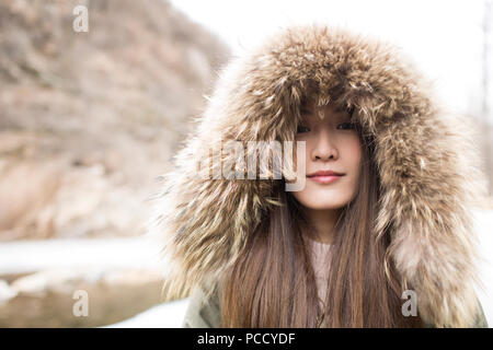 Ritratto di Allegro giovane donna cinese all'aperto in inverno Foto Stock