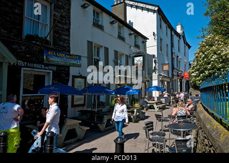 Persone visitatori turisti seduti all'aperto pub e ristoranti in estate Church Street Bowness a Windermere Cumbria Inghilterra Gran Bretagna Foto Stock