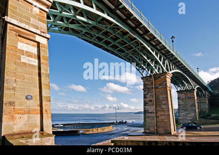 La vista da South Bay tutto il modo a Filey Brigg, visto attraverso gli archi di Scarborough's Spa Bridge in quanto copre la fine della strada di fondovalle. Foto Stock