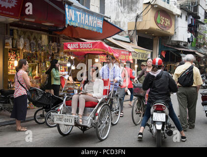 Un turista in un ciclo su una strada trafficata nel vecchio quartiere, Hanoi, Vietnam, Indocina, Asia sud-orientale, Asia Foto Stock