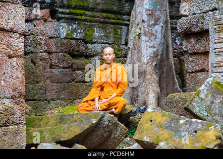 Monaco buddista seduto in una rovina tempio di Angkor, Sito Patrimonio Mondiale dell'UNESCO, Siem Reap, Cambogia, Indocina, Asia sud-orientale, Asia Foto Stock