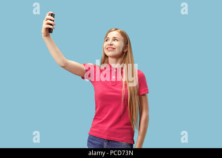 Ritratto di un felice sorridente ragazza casual Mostra schermo vuoto del telefono mobile isolate su sfondo blu Foto Stock