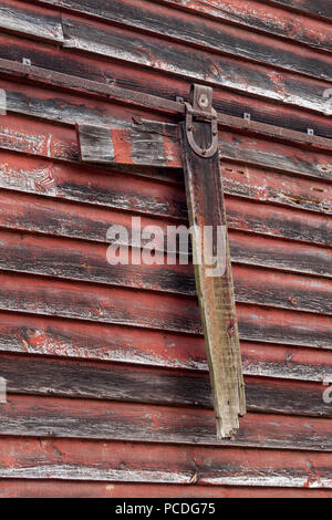 Close-up di una rotta, porta scorrevole parti, appeso fuori il lato di un fienile in Cades Cove nel Parco Nazionale di Great Smoky Mountains vicino a Townsend, Tennessee Foto Stock