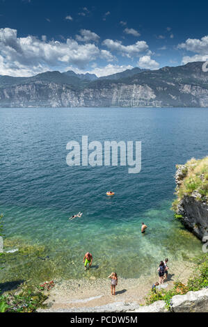 Nuotatori godendo il fresco nuotare nel lago di Garda in una calda giornata estiva. Foto Stock