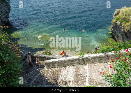 Nuotatori godendo il fresco nuotare nel lago di Garda in una calda giornata estiva. Foto Stock