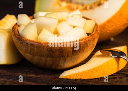 Melone tritati in una ciotola di legno vicino Foto Stock