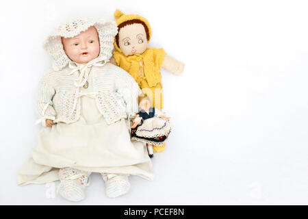 Tre bambole antiche su sfondo bianco
