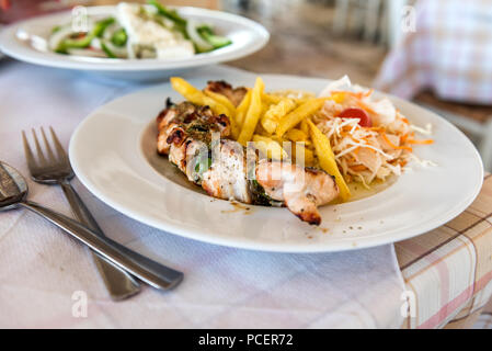 Pasto greco souvlaki di maiale piastra su un tavolo in un ristorante mediterraneo Foto Stock