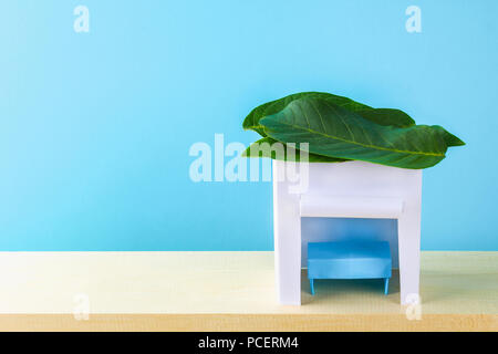 Felice Sukkot. Una capanna fatta di carta rivestito con foglie su uno sfondo blu. Copiare lo spazio Foto Stock