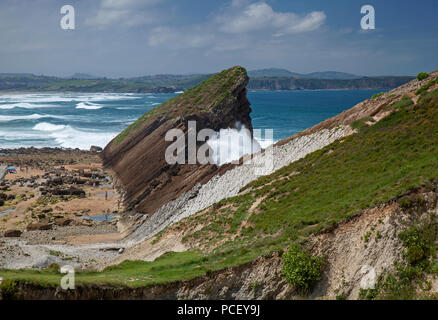 Cantabria, Costa Quebrada attorno a Playa El Madero Beach, spiaggia protetta a sinistra, frangi onda contro le rocce a destra, dolina in primo piano Foto Stock