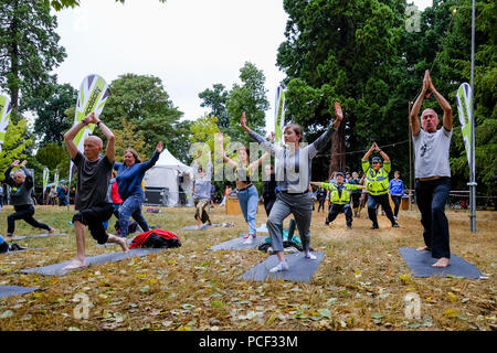 La polizia entra a far parte di una classe di yoga al WOMAD domenica 29 luglio 2018 tenutasi a Charlton Park, Wiltshire . Nella foto: 2 funzionari di polizia del Wiltshire forza di polizia uniti in un libero Yoga classe svolge nel mondo del benessere . Foto Stock