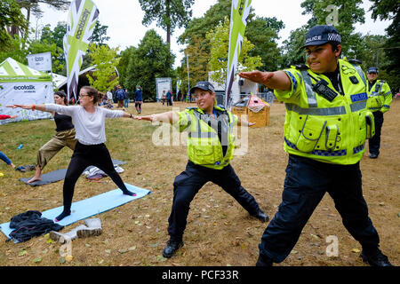La polizia entra a far parte di una classe di yoga al WOMAD domenica 29 luglio 2018 tenutasi a Charlton Park, Wiltshire . Nella foto: 2 funzionari di polizia del Wiltshire forza di polizia uniti in un libero Yoga classe svolge nel mondo del benessere . Foto Stock