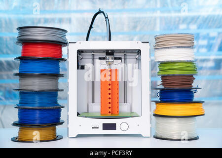 ABS e PLA filament accanto alla stampante 3D. Bobine di plastica Foto Stock