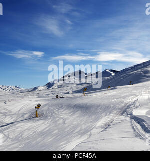 Snowy piste da sci con innevamento programmato a sun mattina. Maggiore Caucaso in inverno, Monte Shahdagh, Azerbaigian. Foto Stock