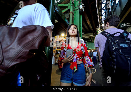 Turisti asiatici in un affollato mercato di Borough, Southwark, Londra, Inghilterra, Regno Unito.