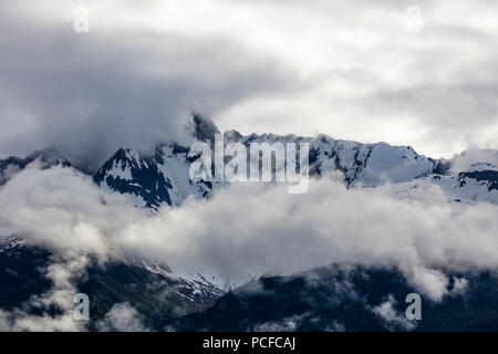 Snow capped aspre montagne rocciose in nubi sulla Penisola di Kenai dell Alaska Foto Stock