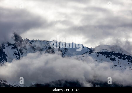 Snow capped aspre montagne rocciose in nubi sulla Penisola di Kenai dell Alaska Foto Stock