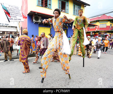 Porto di Spagna, di Trinidad e Tobago. 1 agosto 2018. Giovani Moko Jumbie ballerini eseguono durante l annuale Giornata di emancipazione rispetto processione da Piazza Indipendenza al Lidj Yasu Omowale emancipazione villaggio nel Queens' Park Savannah il 1 agosto 2018 nel porto di Spagna, Trinidad. (Foto di Sean I draghetti/Alamy Live News) Foto Stock